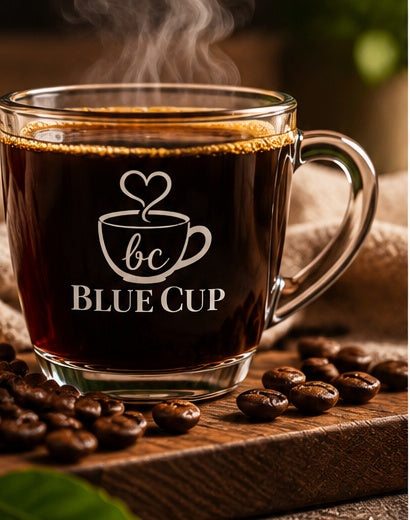 Steaming Blue Cup coffee served in a branded glass mug with coffee beans